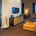 Hard Rock Hotel & Casino Sioux City suite with seating area, guitar decor and brick accent wall