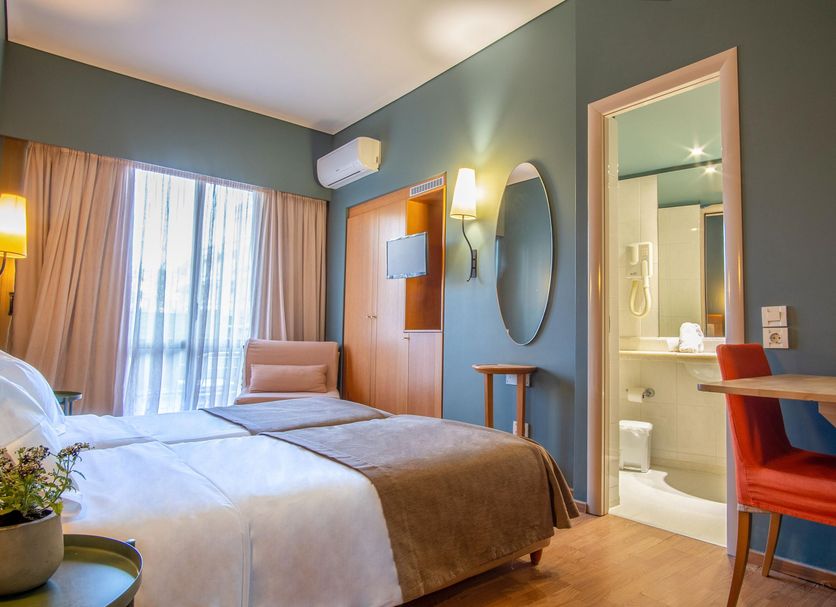Hotel Olympic Heraklion guest room with bed, desk, balcony door and en suite bathroom