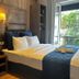 Hôtel Clairefontaine Paris guest room with double bed, desk, warm lighting, and open window view