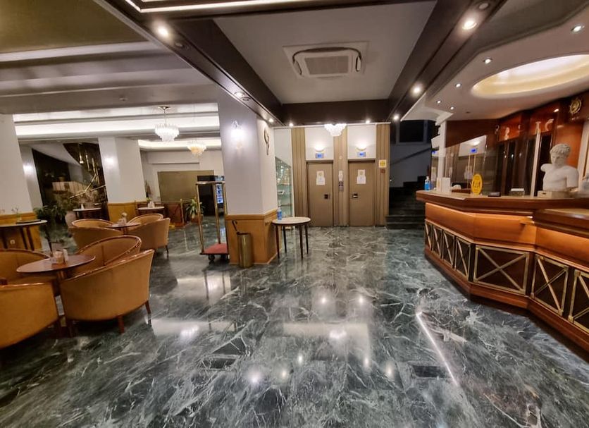 Savoy Hotel in Piraeus lobby with polished marble floor, seating area, and reception desk