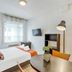 Appart'City Classic Thonon Les Bains guest room with bed, desk, wall-mounted TV and window in Thonon-les-Bains