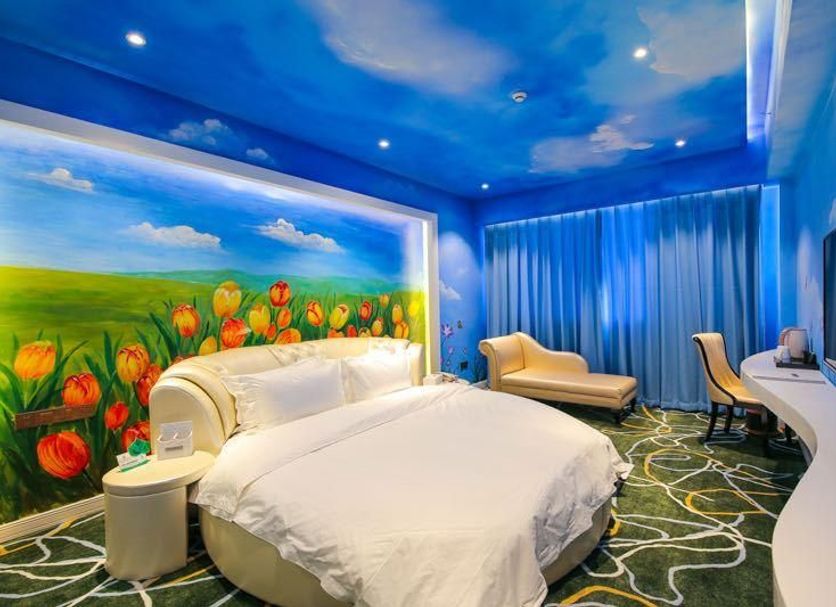 Longwan Hotel (Foshan Ceramics City) room with tulip mural, blue sky ceiling, and chaise lounge in Foshan