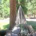 Sierra Sky Lodge in Graeagle: outdoor patio table with folding chairs and umbrella among trees