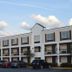 Days Inn by Wyndham Marietta-Atlanta-Delk Road exterior in Marietta with parked cars and blue sky