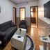 Al-Nujoom Hotel Suites in Amman: compact lounge with black sofa, armchair, coffee table, and wall TV