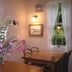 Pension Wave Inn in Itō dining room with wooden tables, flowers, wall art and garden-view window