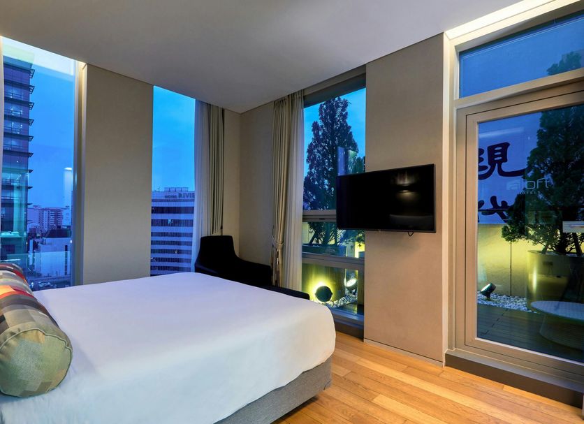 Aloft Seoul Gangnam guest room with large windows, city view, and wall-mounted TV in Seoul