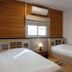 The Goose House Ubon room in Ubon Ratchathani with two single beds, window and air conditioner