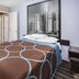 Super 8 by Wyndham Marysville/Port Huron Area guest room with bed and cityscape wall art