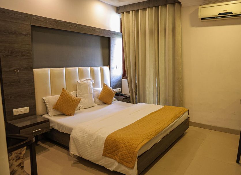 Hotel Park Plaza Chandigarh guest room with king bed, pillows, curtains and wall-mounted AC