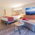 Wohlfühlhotel Schiestl in Fügenberg room with bed, sofa, and mountain wall art