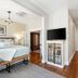 Mossbrae Hotel in Dunsmuir bedroom with king bed, wall TV, wood floors and bench seating