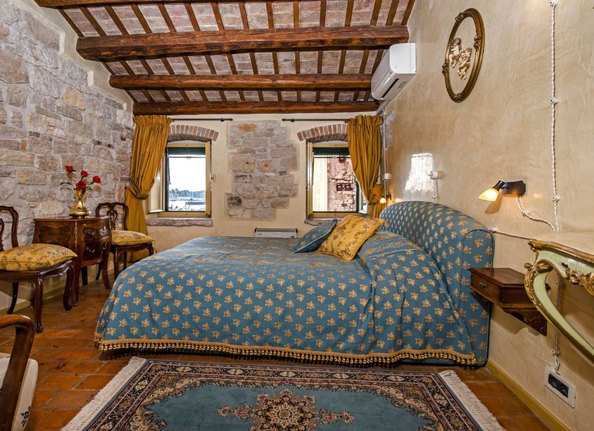 Residence Porta Antica Centro Storico Rovinj room with stone walls, wood beams, double bed, and two windows