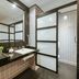 Pestana Curitiba bathroom with walk-in shower, black countertop vanity and frosted glass partitions