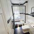 The Lawrence Burnley bathroom with walk-in shower, wall-mounted sink, toilet and black trim accents
