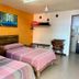 El Rincón de Doña Bety Oaxaca room with two beds, colorful wall art, and a small table