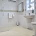 The Appleby Inn Hotel Swadlincote bathroom with walk-in glass shower, sink, toilet, and wall mirror