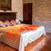 Hotel Posada De Roger in Puerto Vallarta: guest room with king bed, colorful pillows, wooden desk and tiled floor