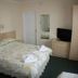 The Glendeveor Newquay guest room with double bed, TV, dresser and wardrobe