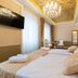 Central Square Heritage Hotel in Split: elegant guest room with chandelier, tufted bed, and sitting area