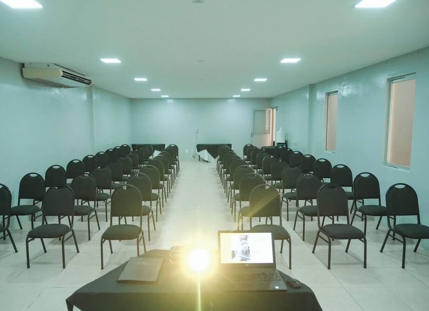 Hotel Villaoeste in Mossoró meeting room with rows of black chairs and a laptop at the front