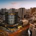 Neo Deda Hotel in Deyang at dusk, with a modern curved tower rising above the city skyline
