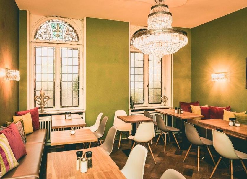 Hotel Villa Klemm - Wiesbaden City dining room with chandeliers, green walls, arched windows and tables