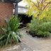 Crown Accommodation Bendigo Cbd courtyard with brick wall, potted plants and tiled walkway in Bendigo