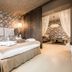 Meltar Boutique Hotel in Asiago, boutique bedroom with floral wallpaper and adjoining sitting area