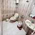 Stayguru Usha Residency, Bhuj: compact tiled bathroom with toilet, sink, mirror, shower and water heater