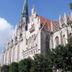 Hotel Stadt Mühlhausen in Mühlhausen, beside a Gothic church with a tall spire and blue sky
