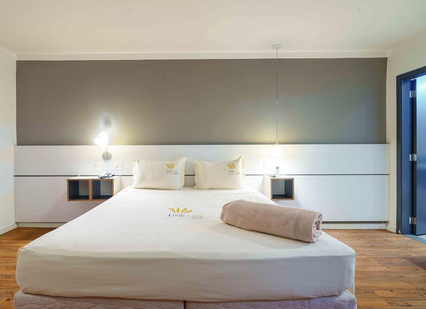 Uniclass Hotel Pinheiros in Sao Paulo guest room with a neatly made bed and modern minimalist decor
