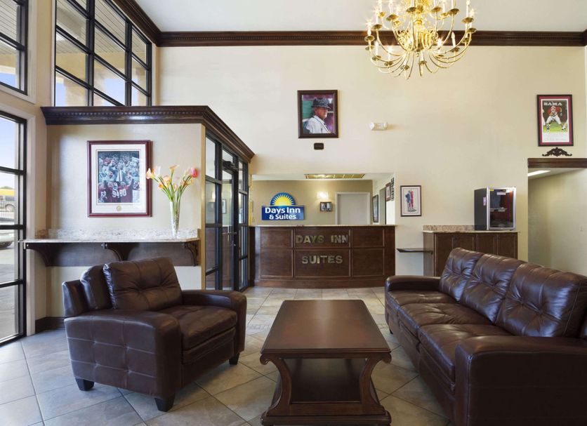 Days Inn & Suites by Wyndham Tuscaloosa lobby with leather seating, chandelier, and front desk