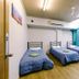 Global Backpackers Cairns Central dorm room with three single beds and turquoise accent wall in Cairns