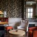 Chateau Cordeillan-Bages in Pauillac, elegant lounge with floral wallpaper, fireplace, and armchairs