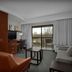 Courtyard by Marriott Greensboro Airport guest room with balcony view, sofa, desk and TV in Greensboro