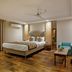 Hotel Waves, Delhi Airport in New Delhi: modern guest room with king bed, teal seating and wood flooring