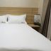 Center Of City Creo Hotel room with double bed, wood headboard and bedside lamp in Yanbian