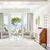 The Danai, Nikiti: bright sea-view suite with open balcony doors, chairs, and a tree-framed ocean view