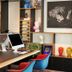 citizenM Rome Isola Tiberina lobby with colorful chairs, art-filled shelves, and computer workstation in Rome