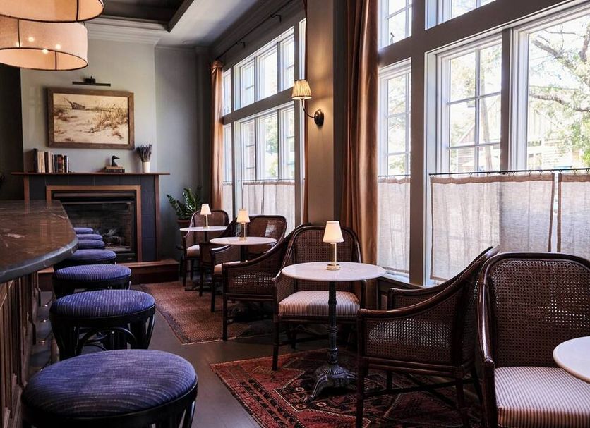 The Harbor Front Inn in Greenport lounge with large windows, fireplace, tables and seating