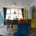 Villahotel Vlissingen lounge with colorful seating, yellow bar, and arched interior in Vlissingen