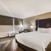 Clarion Inn & Suites Florence - Darlington guest room with king bed, dark headboard and bedside lamps