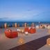 Dreams Aventuras Riviera Maya in Puerto Aventuras with beachfront lounge seating and lit lanterns at sunset
