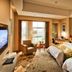 Guanyuan Liusu Hotel in Suzhou guest room with two beds, armchair, desk and window seating area
