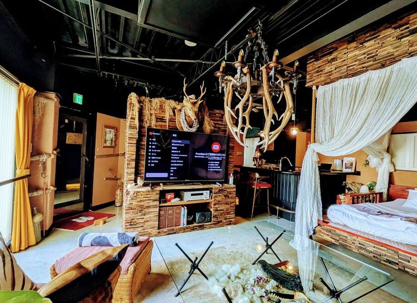 Yadoya Lodge Kyoto room with deer antlers, TV, and canopy bed
