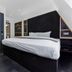 The Z Hotel Holborn, London room with bed beside a frosted glass elevator and built-in shelving
