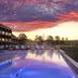 Der Öschberghof in Donaueschingen at sunset, with an outdoor pool beside a golf course and terrace loungers