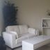 Happy Valley House Phoenix room with white sofa, coffee table, bookshelf and mini fridge
