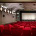 Hotel Du Port in Nogent-sur-Marne conference hall with rows of red seats and a large projection screen